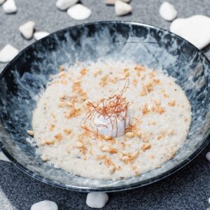 Truffle wheat porridge with poached egg and pine nuts